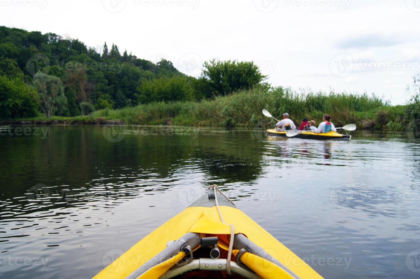 Family rowing in a yellow kayak in summer of Seversky Donets river. photo