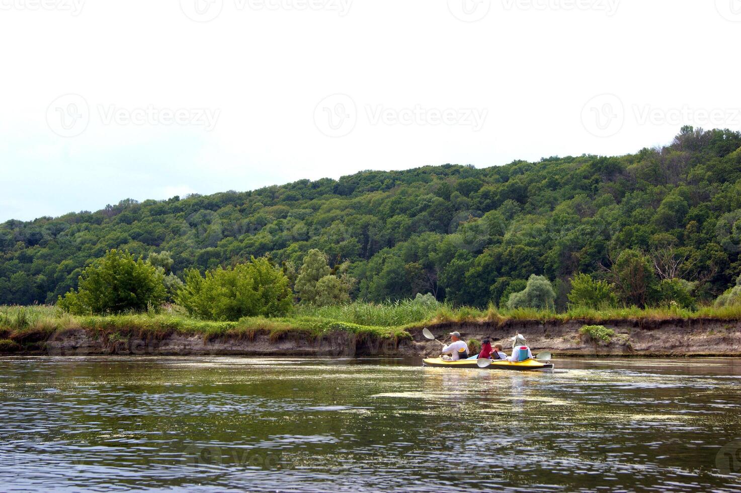 Family rowing in a yellow kayak in summer of Seversky Donets river. photo