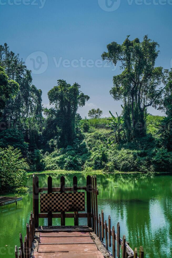 wooden bridge over the lake as a place to take photos with a sky background with free space for photocopies.