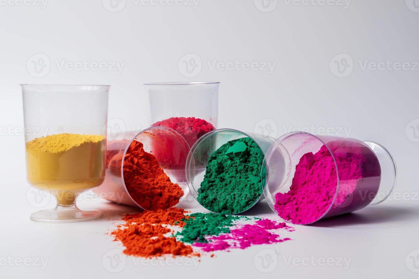 Colorful holi powder in a glass container isolated on white background. photo