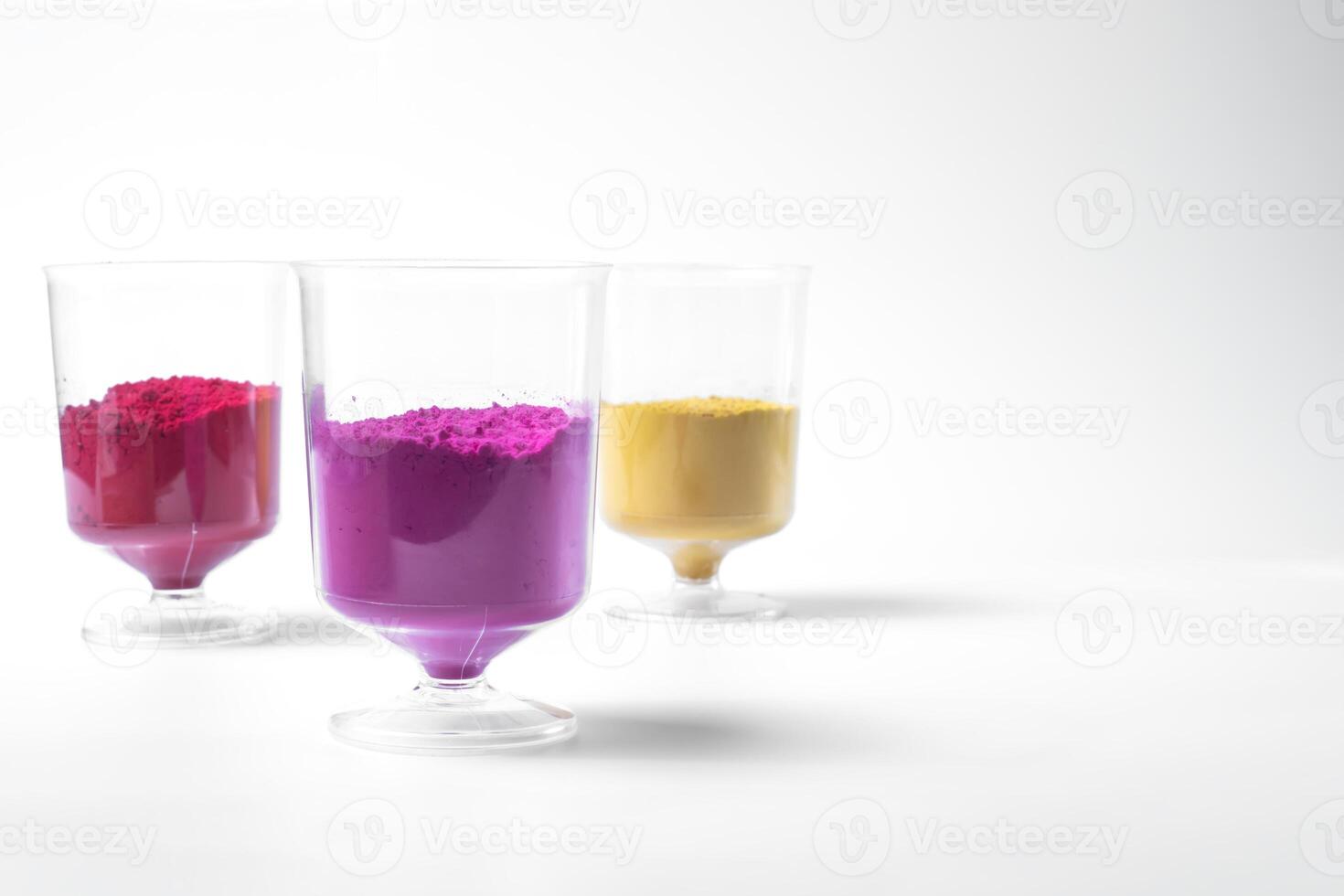 Multicolored holi powder in a glass isolated on white background. Holi powder is a traditional Indian Festival. photo