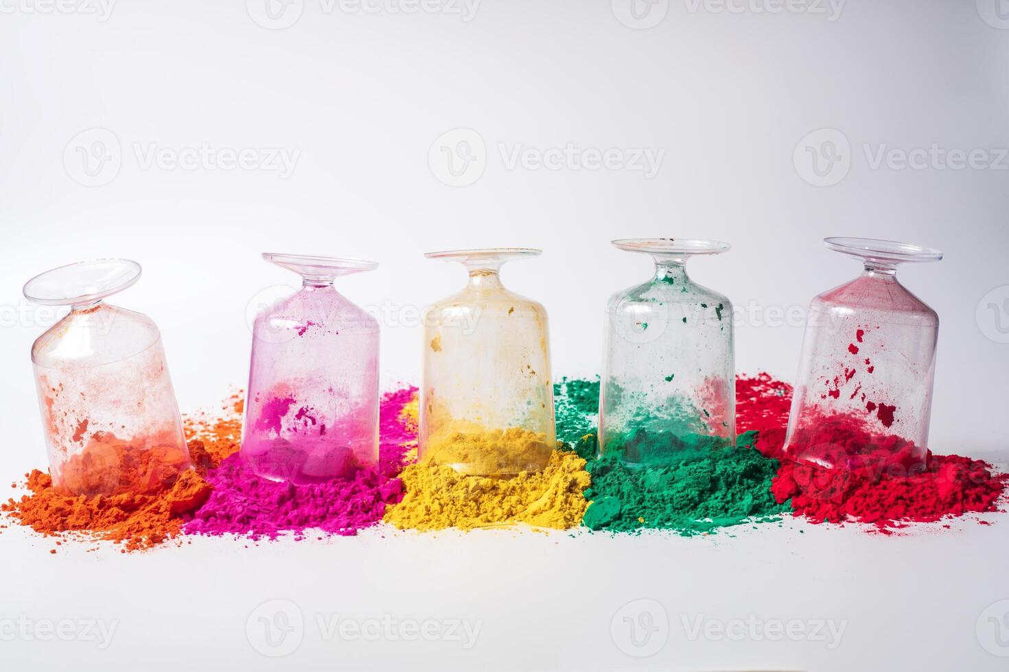 Various colorful holi powder in glass bottles isolated on white background. photo