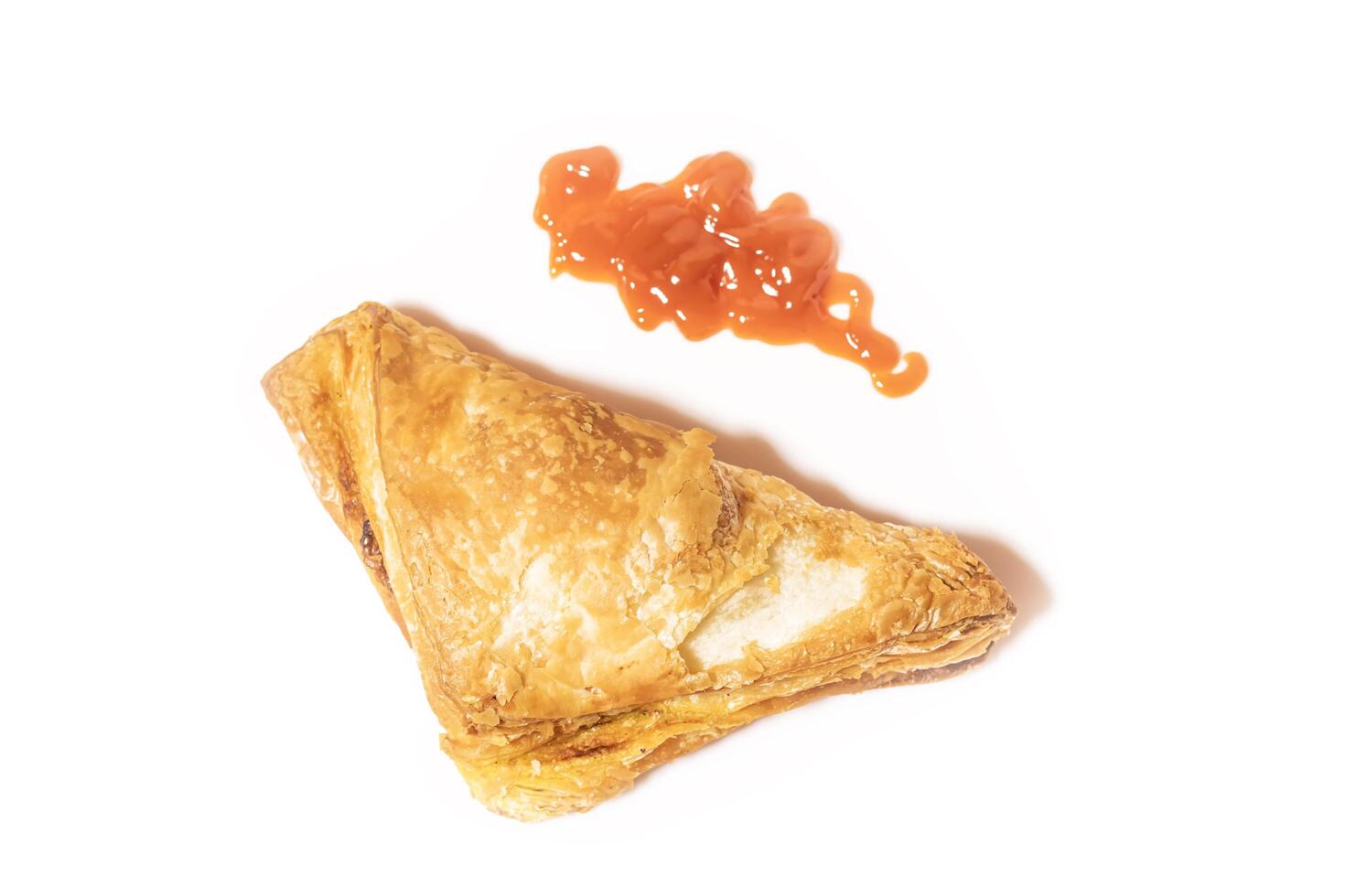 Veg Puff Pastry with tomato sauce isolated on a white background. Top view photo