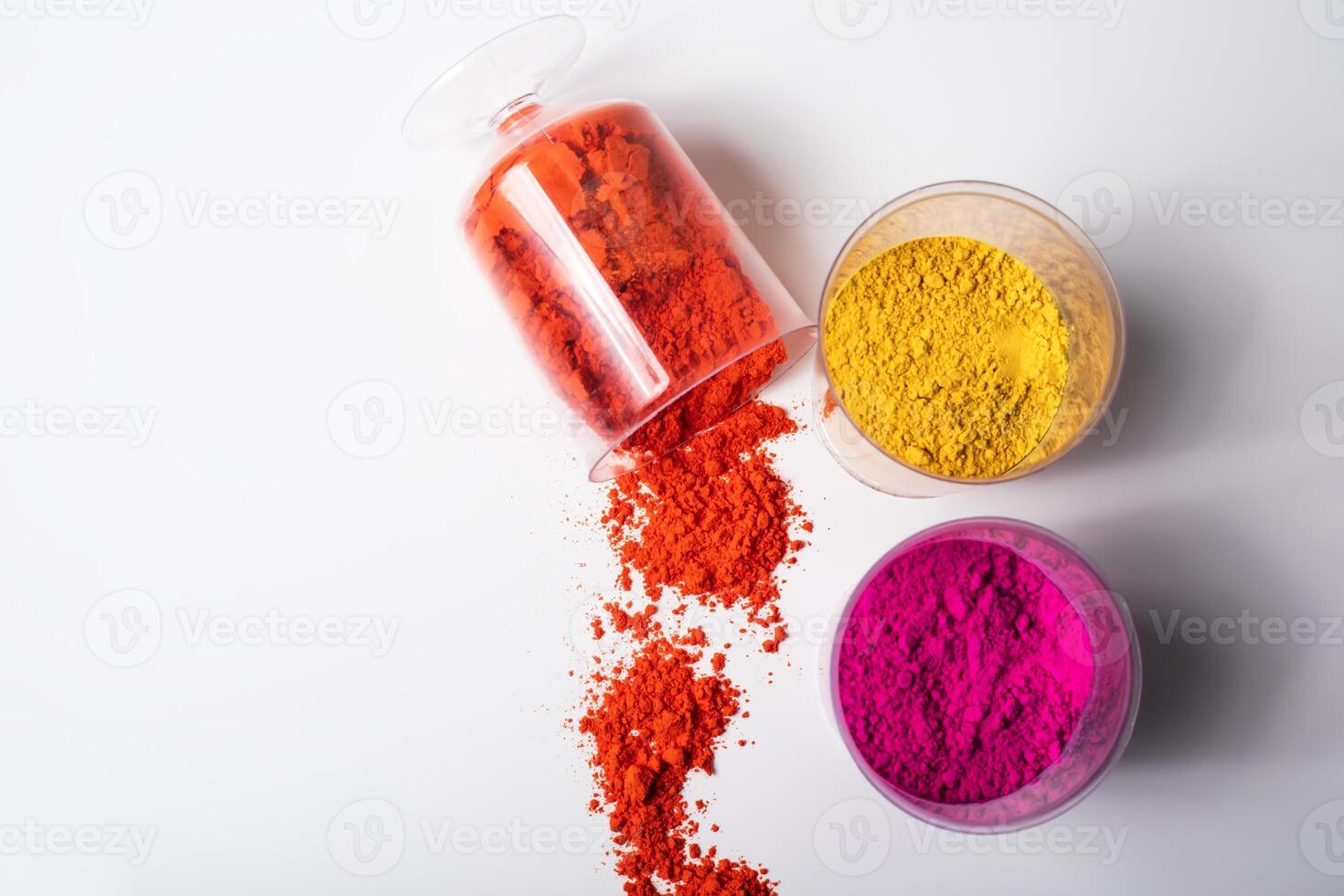 Colorful holi powder in a glass container on a white background photo