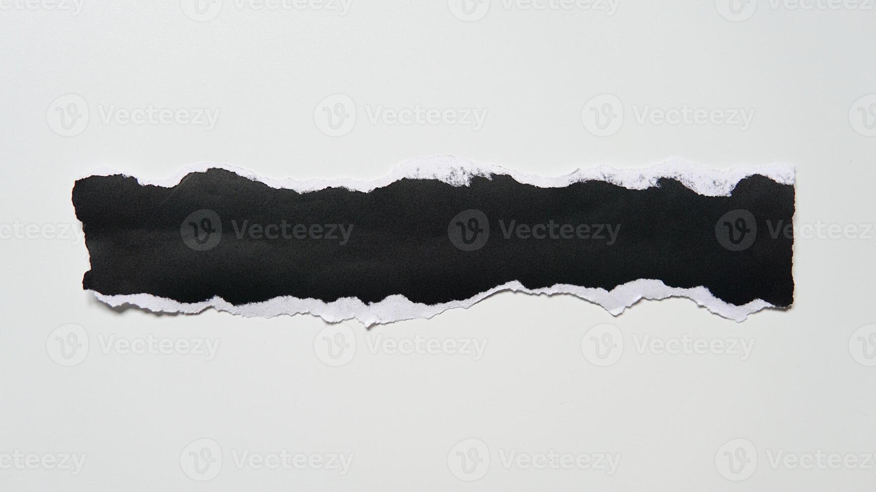 Torn black paper sheet isolated on white background photo