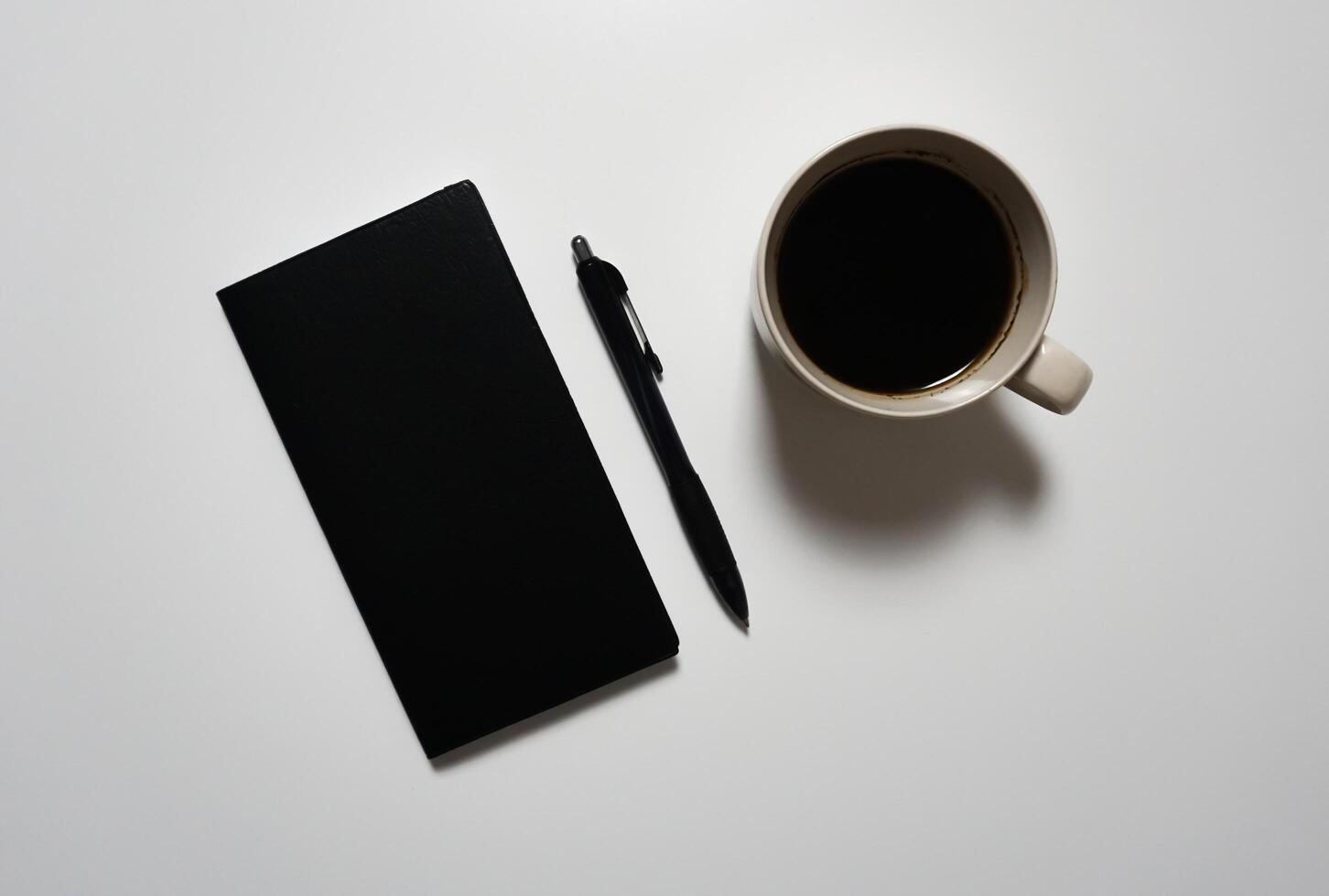 Coffee, smart phone, notebook and pen on white background. photo