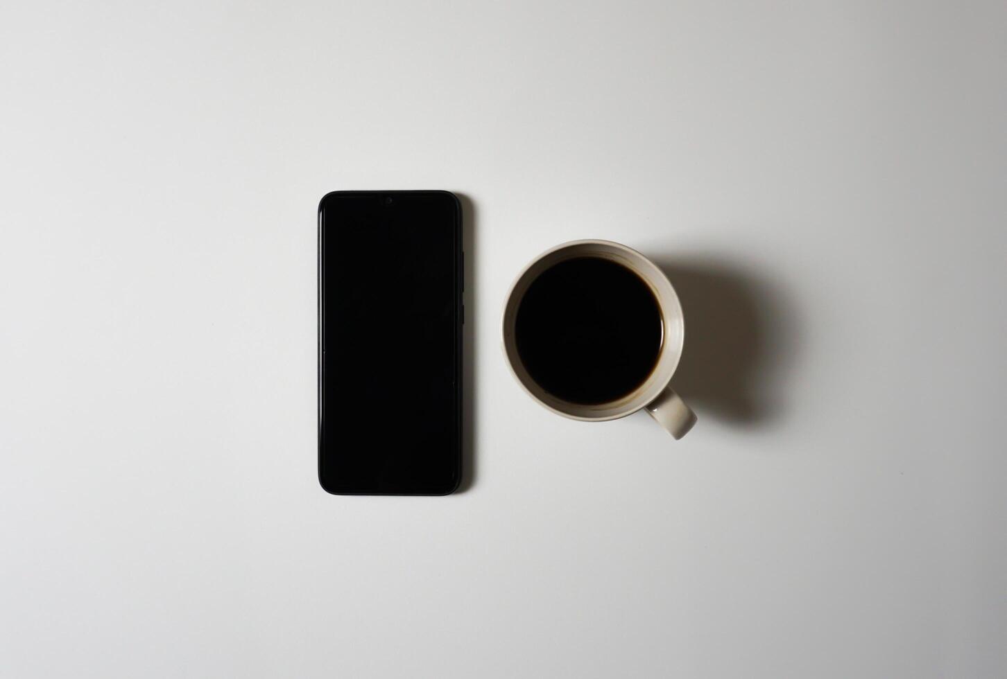 Black coffee and smart phone on white background. photo