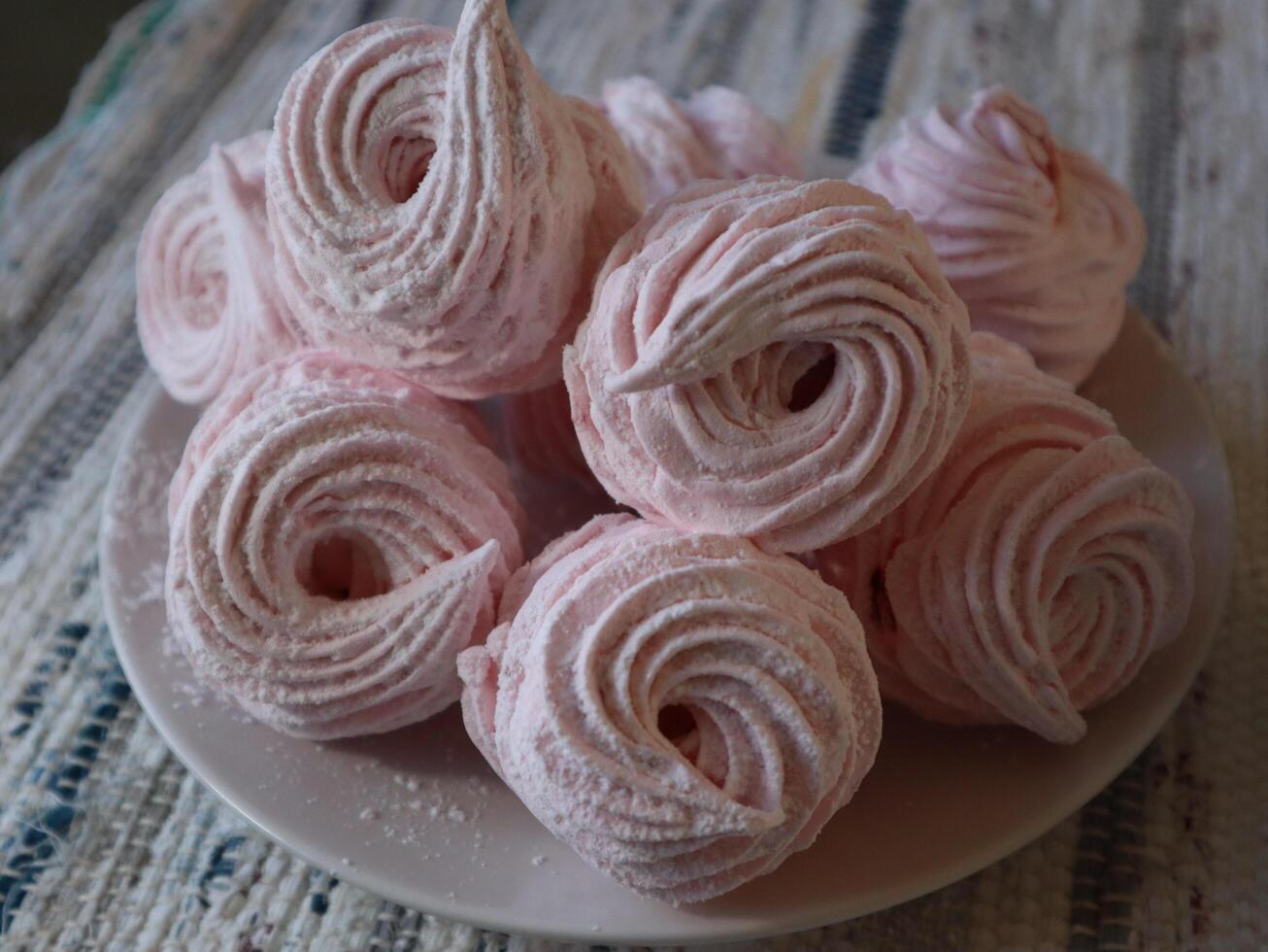 Pink homemade sweet marshmallow zephyr dessert on a white plate photo