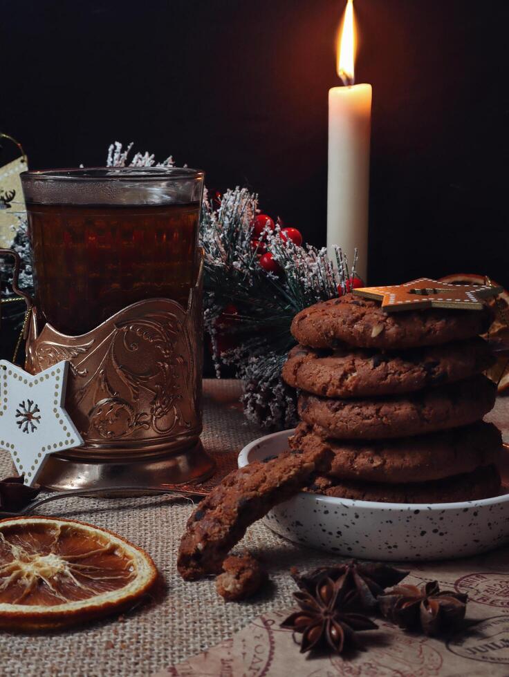 Christmas time served table with hot drink and chocolate cookies with candles and pine tree photo