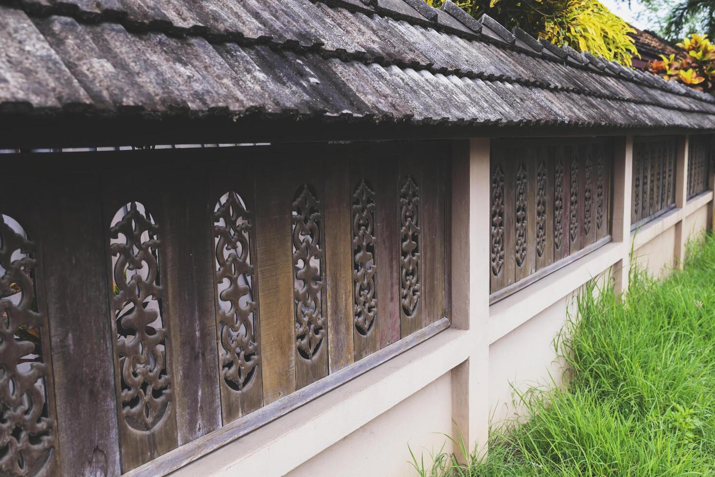 Fence walls with stenciled wood carvings adorn the retro style fence. photo