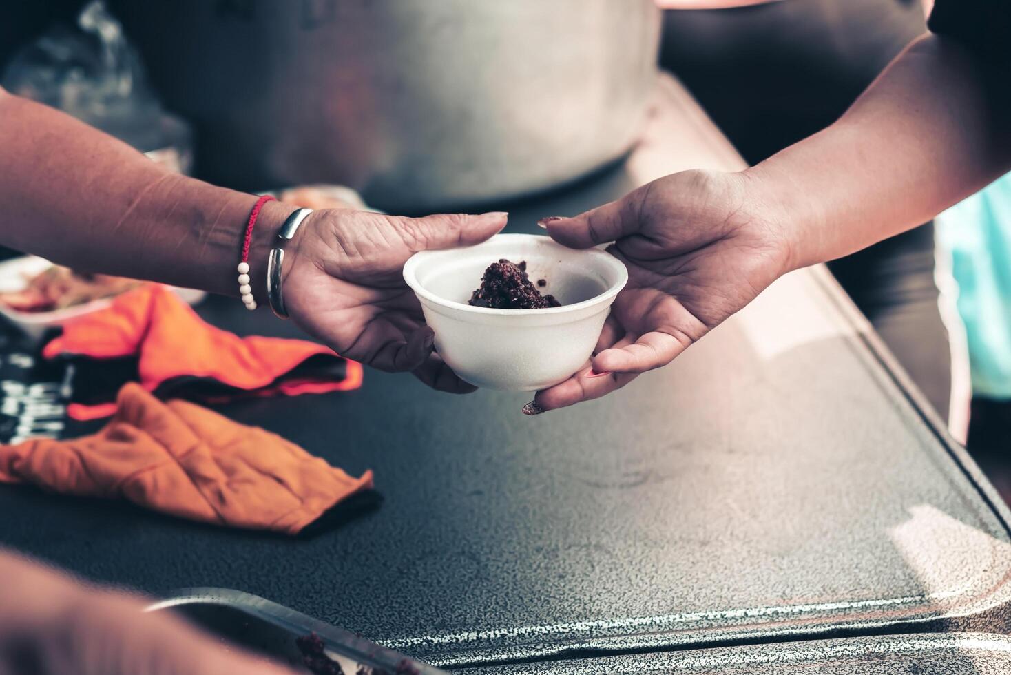 Volunteers handing delicious food to the homeless poor . concept of hunger problem photo