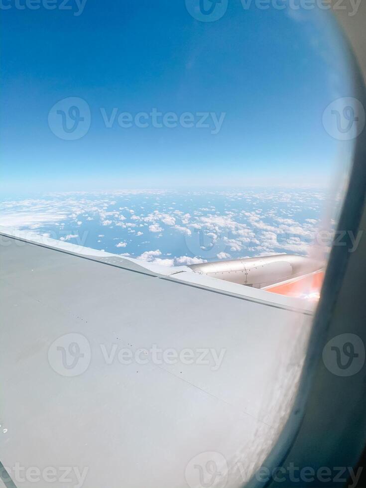 Airplane in air with blue clouds. Airplane window. Traveling photo