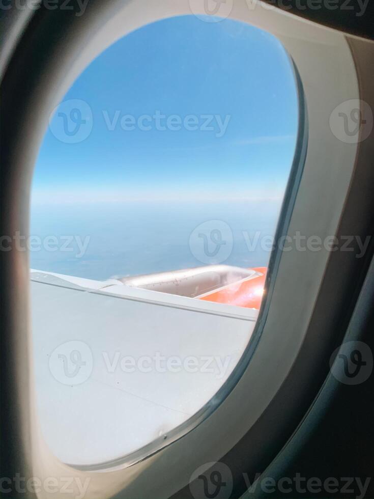 Airplane in air with blue clouds. Airplane window. Traveling photo