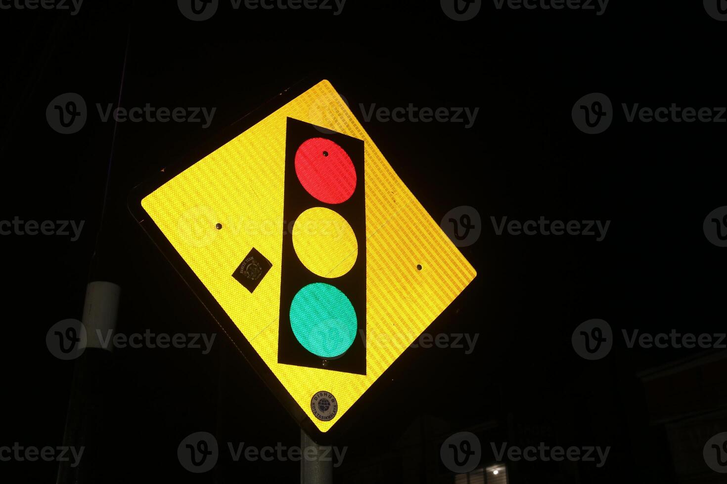 Photo of iron triangular traffic light signs at night