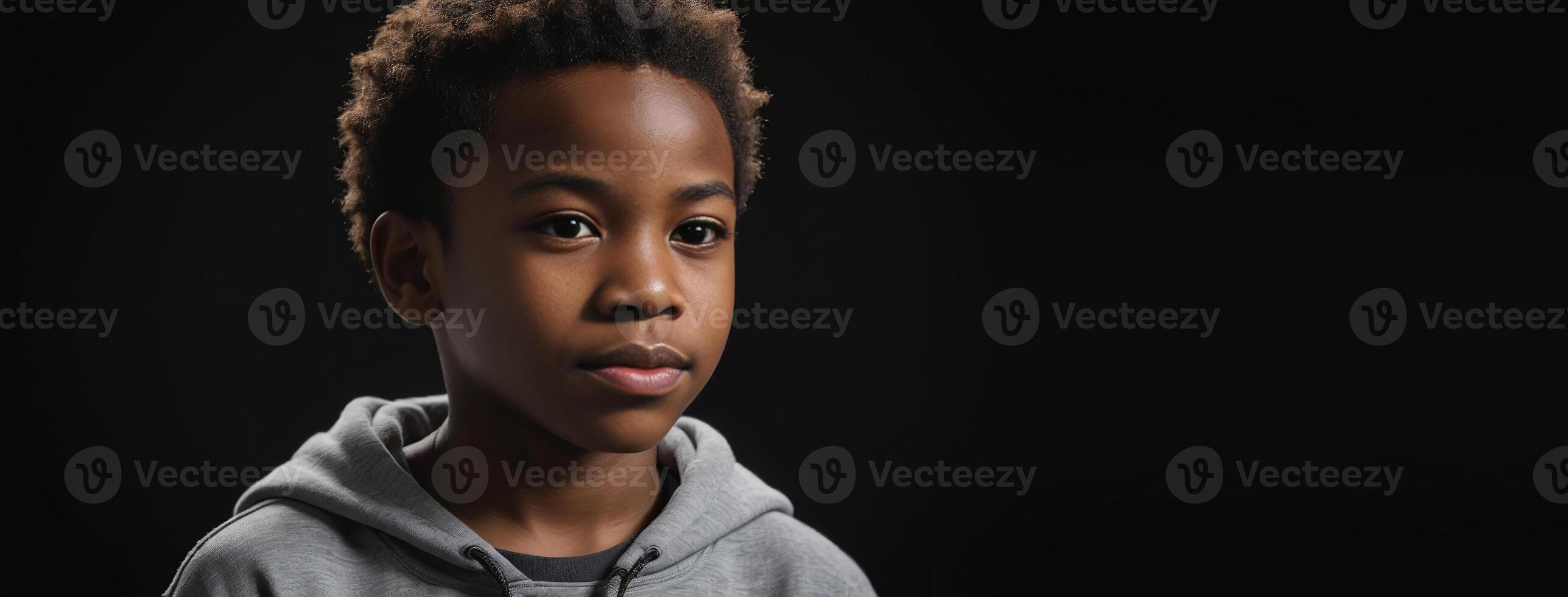 An African American Juvenile Boy Isolated On A Black Background With Copy Space. photo