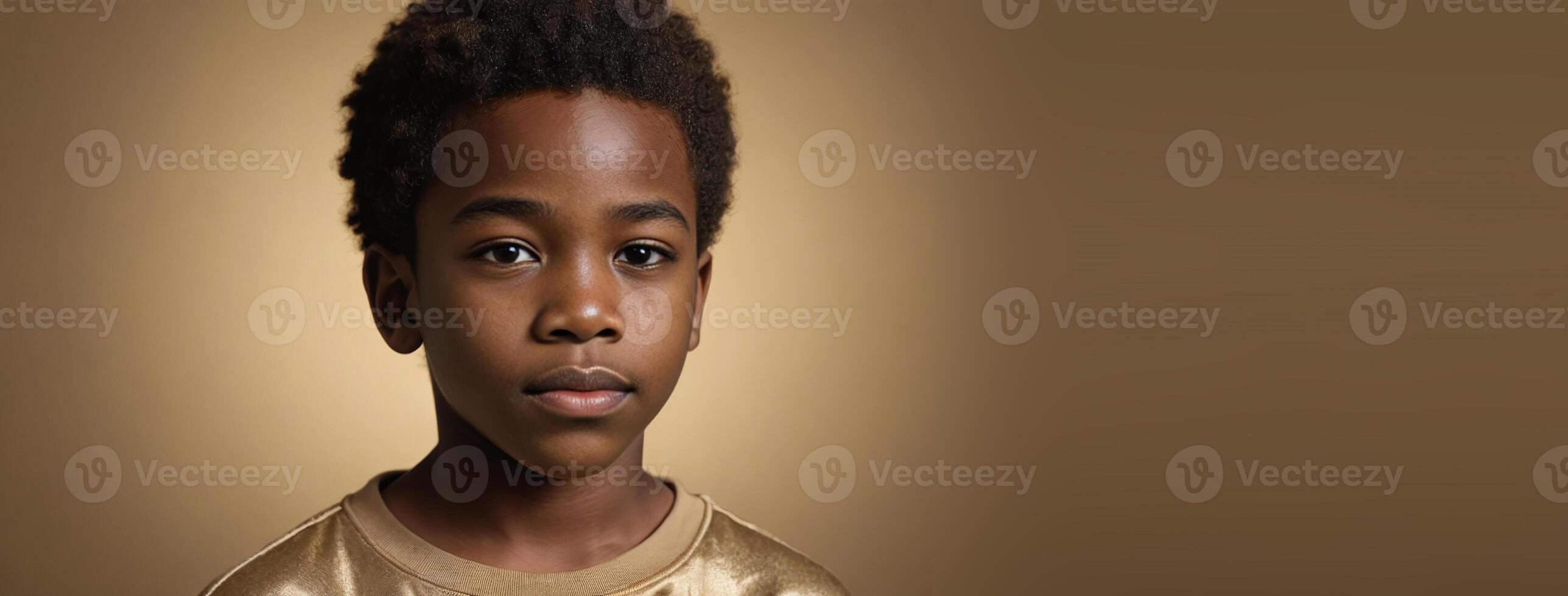 An African American Juvenile Boy Isolated On A Gold Background With Copy Space. photo