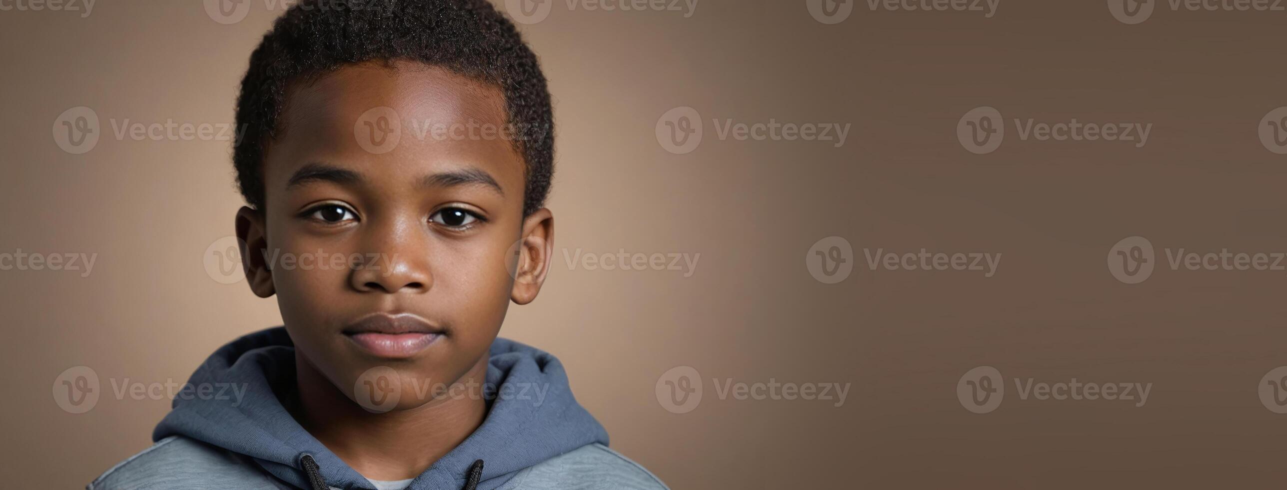 An African American Youngster Boy Isolated On A Hazel Background With Copy Space. photo