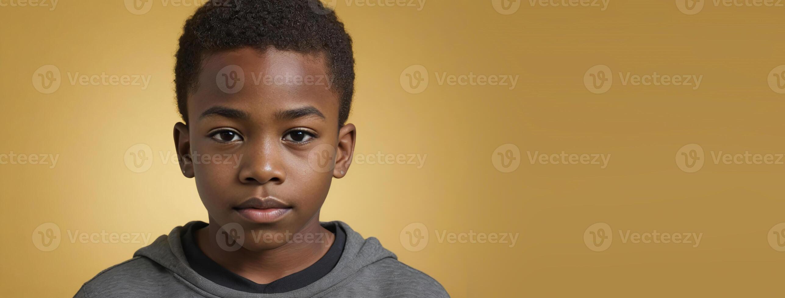 An African American Youthful Boy Isolated On A Yellow Background With Copy Space. photo
