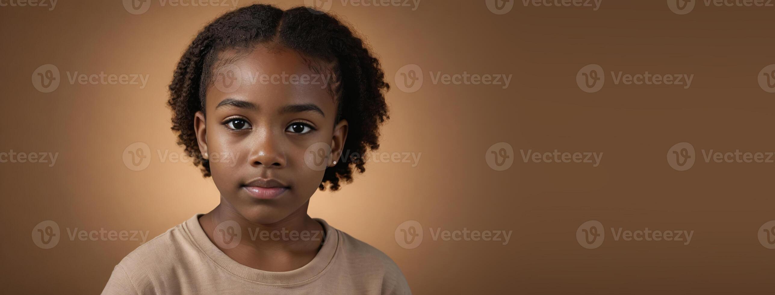 An African American Juvenile Girl Isolated On A Amber Background With Copy Space. photo