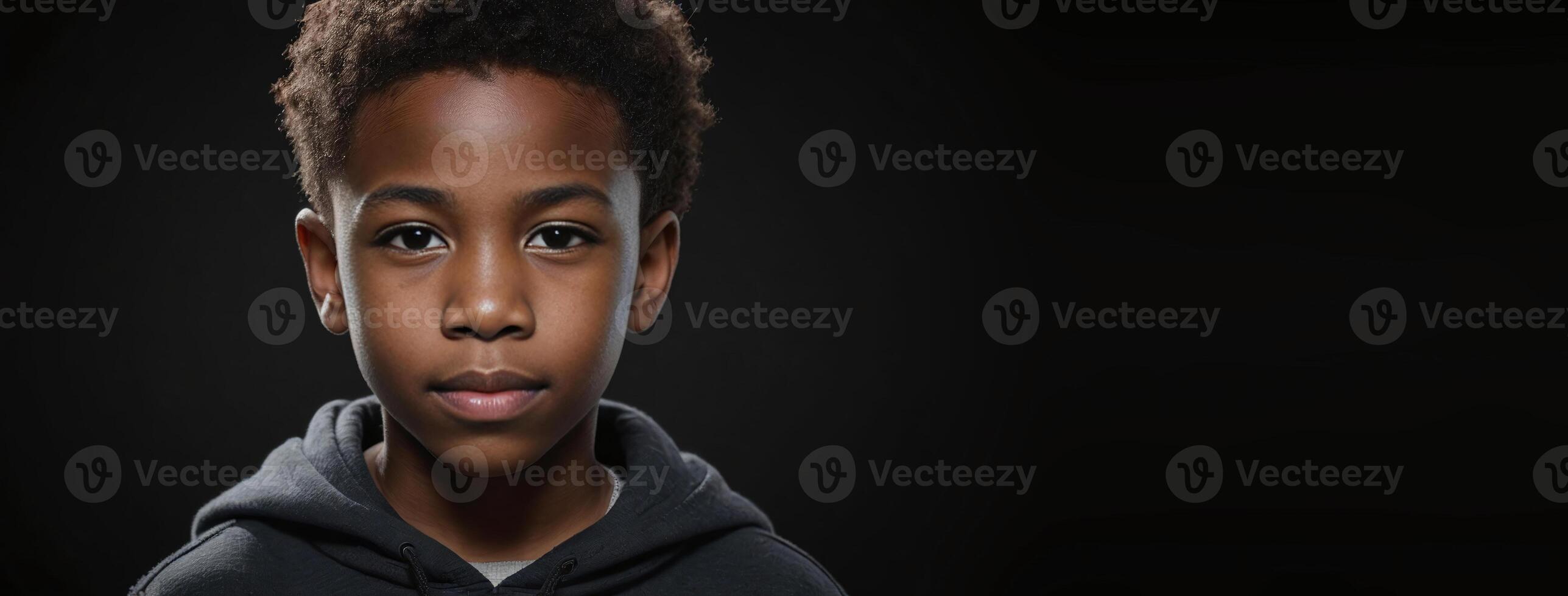 An African American Juvenile Boy Isolated On A Black Background With Copy Space. photo