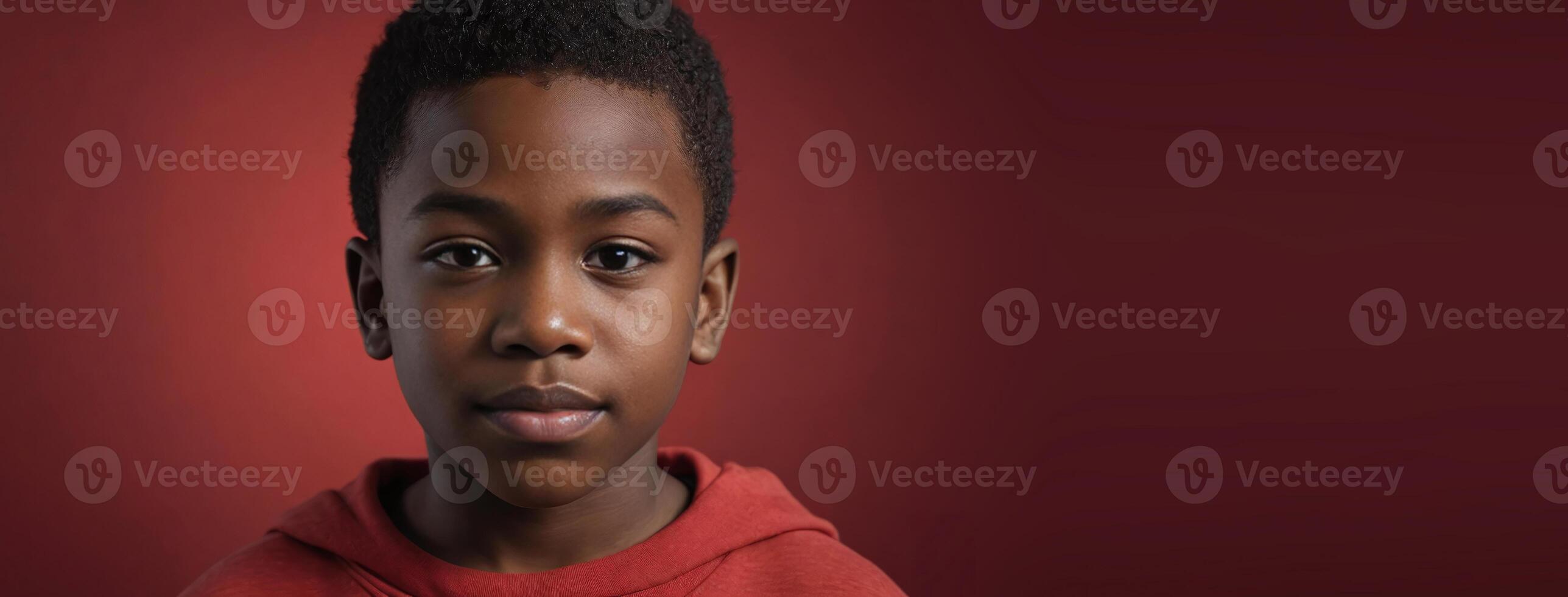 An African American Juvenile Boy Isolated On A Red Background With Copy Space. photo