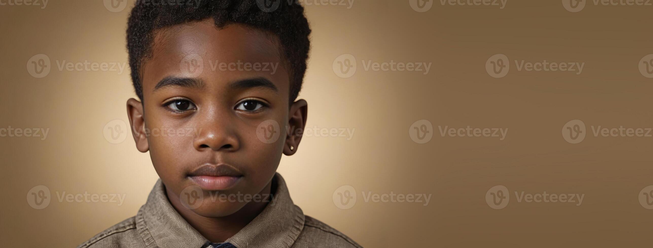 An African American Juvenile Boy Isolated On A Gold Background With Copy Space. photo