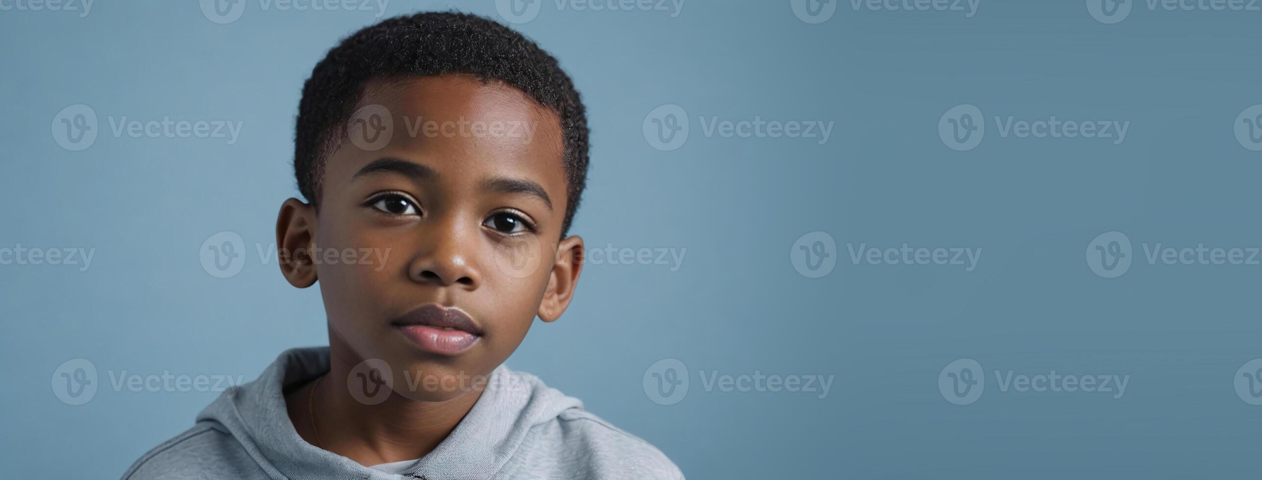 An African American Juvenile Boy Isolated On A Light Blue Background With Copy Space. photo