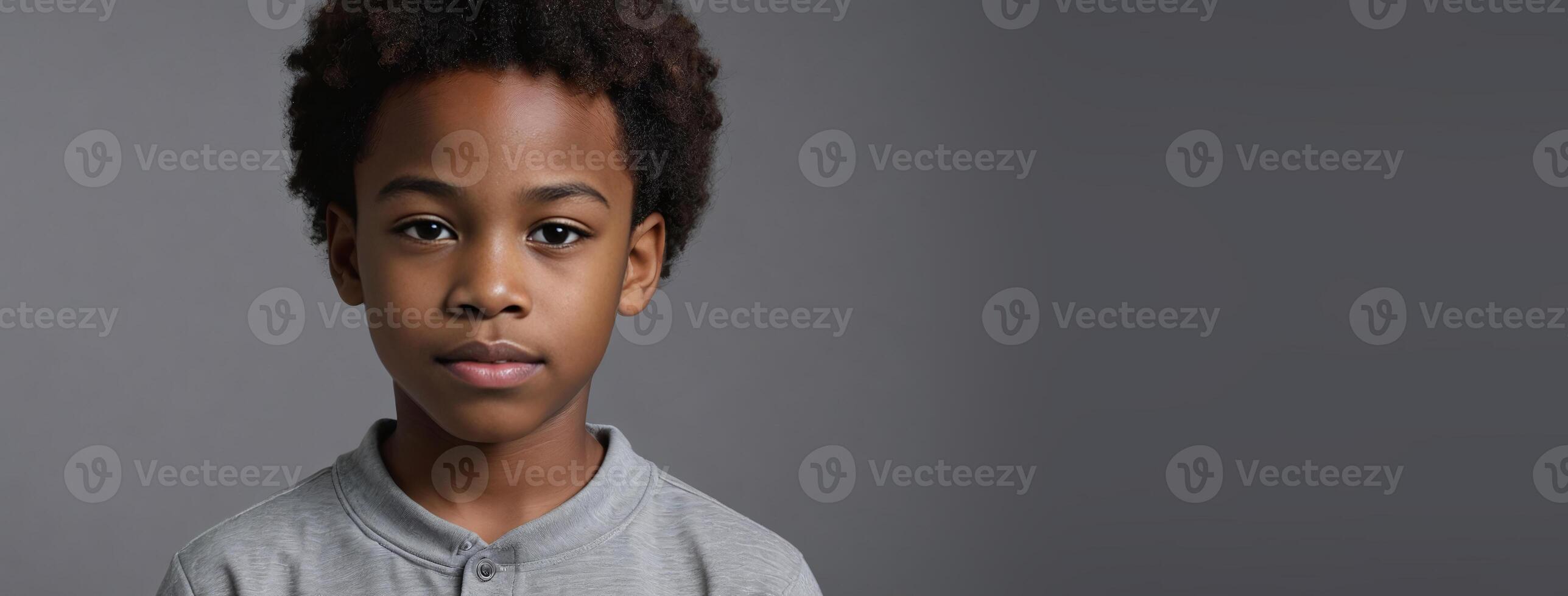 An African American Juvenile Boy Isolated On A Grey Background With Copy Space. photo