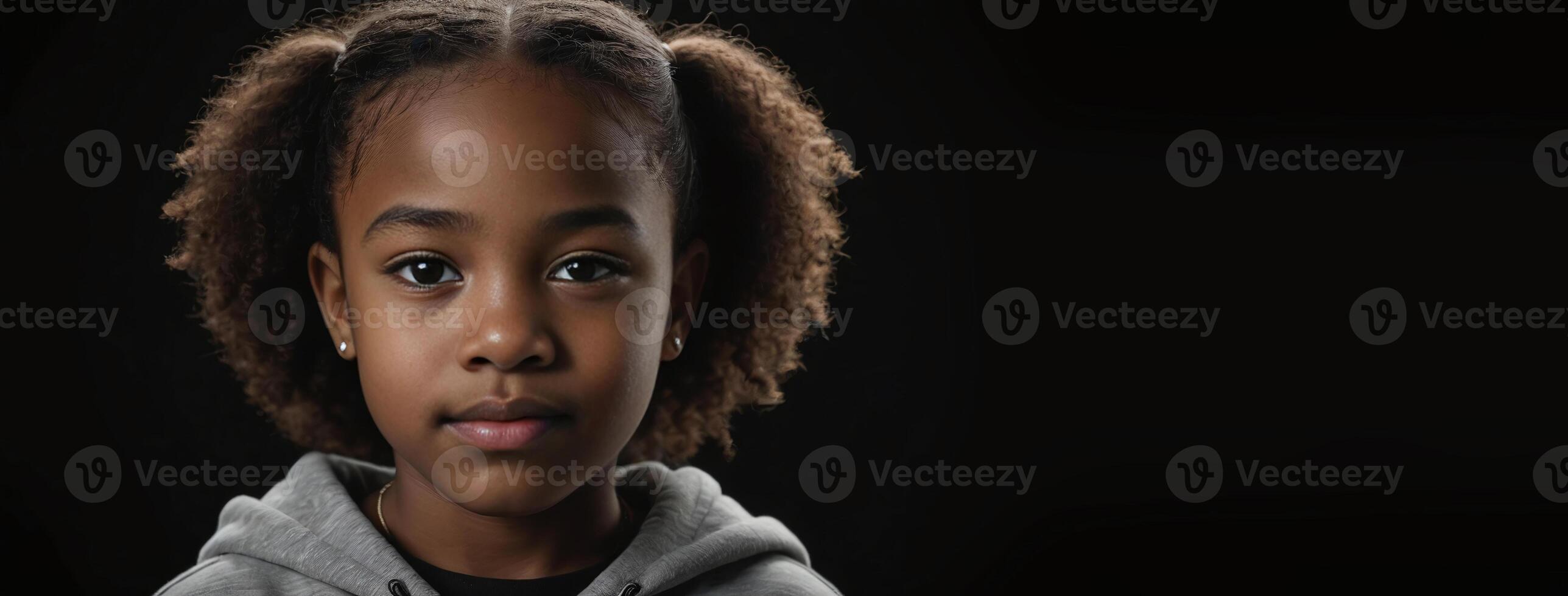 An African American Juvenile Girl Isolated On A Black Background With Copy Space. photo
