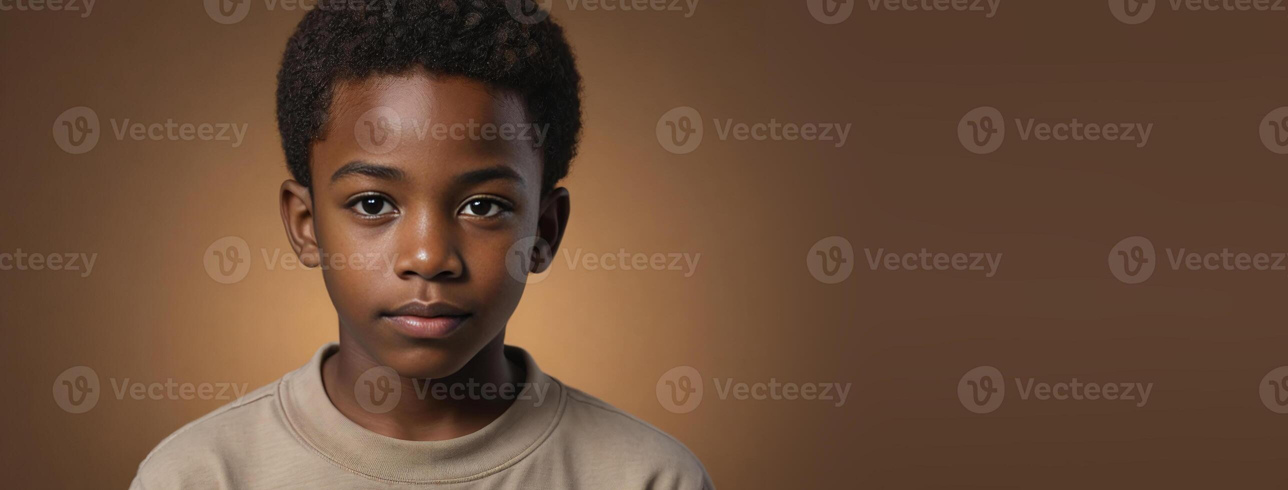 An African American Juvenile Boy Isolated On A Amber Background With Copy Space. photo