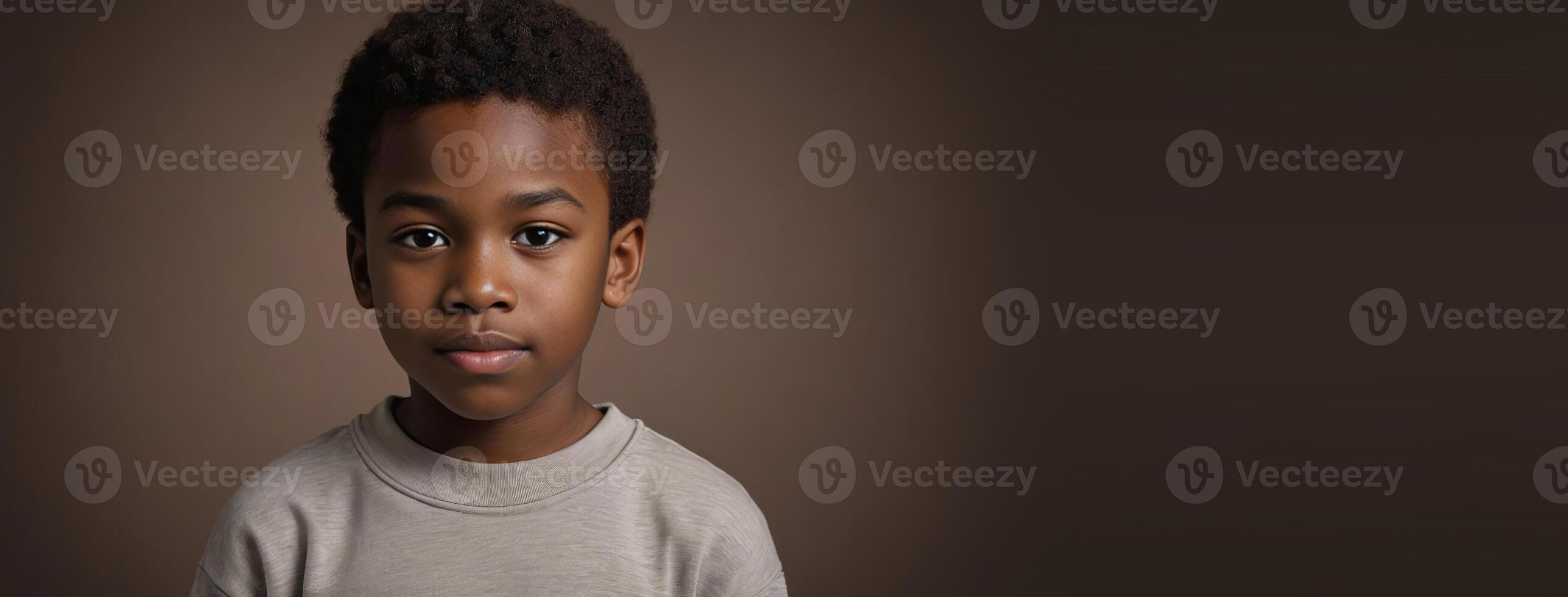 An African American Juvenile Boy Isolated On A Brown Background With Copy Space. photo