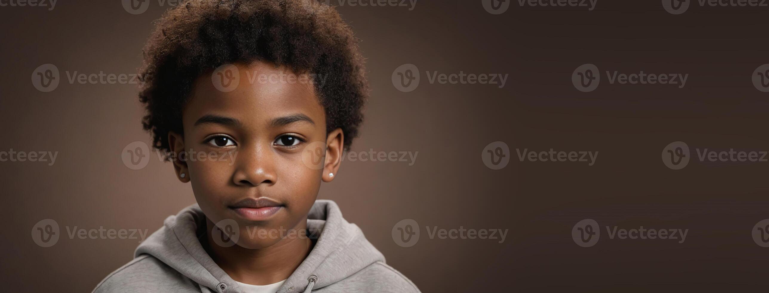 An African American Juvenile Boy Isolated On A Brown Background With Copy Space. photo