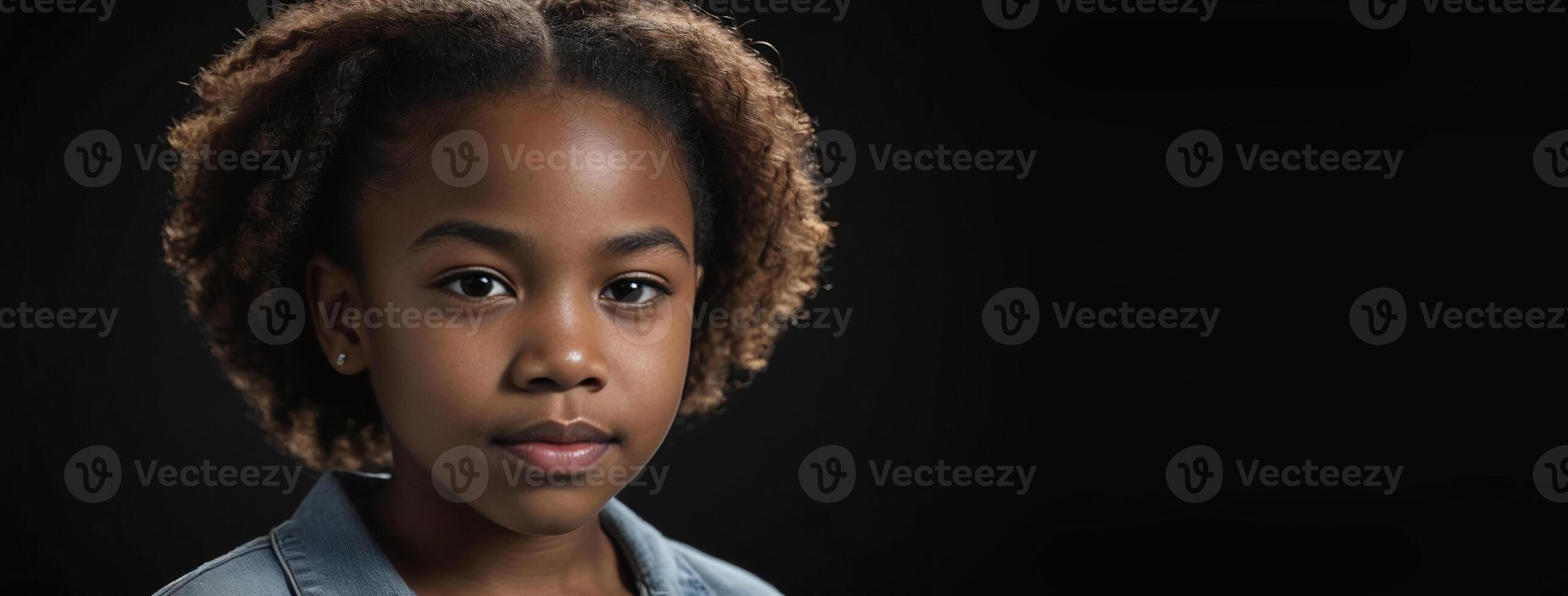 An African American Juvenile Girl Isolated On A Black Background With Copy Space. photo