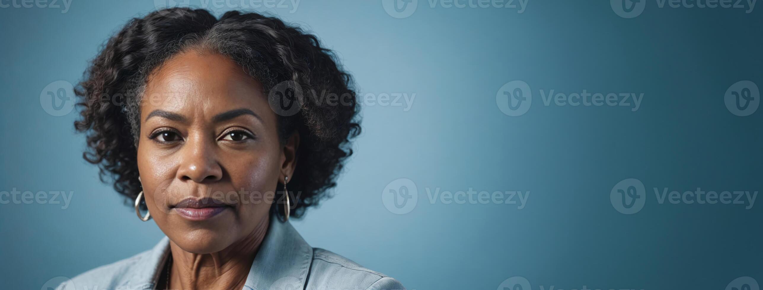 A 50S Adult African American Woman Isolated On A Ice Blue Background With Copy Space. photo