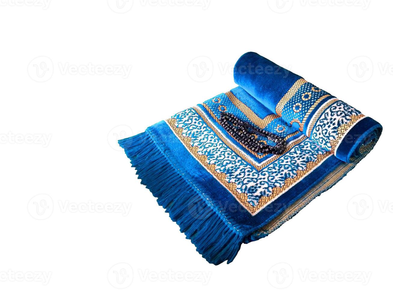 Folded Muslim prayer mat used to pay on white background photo