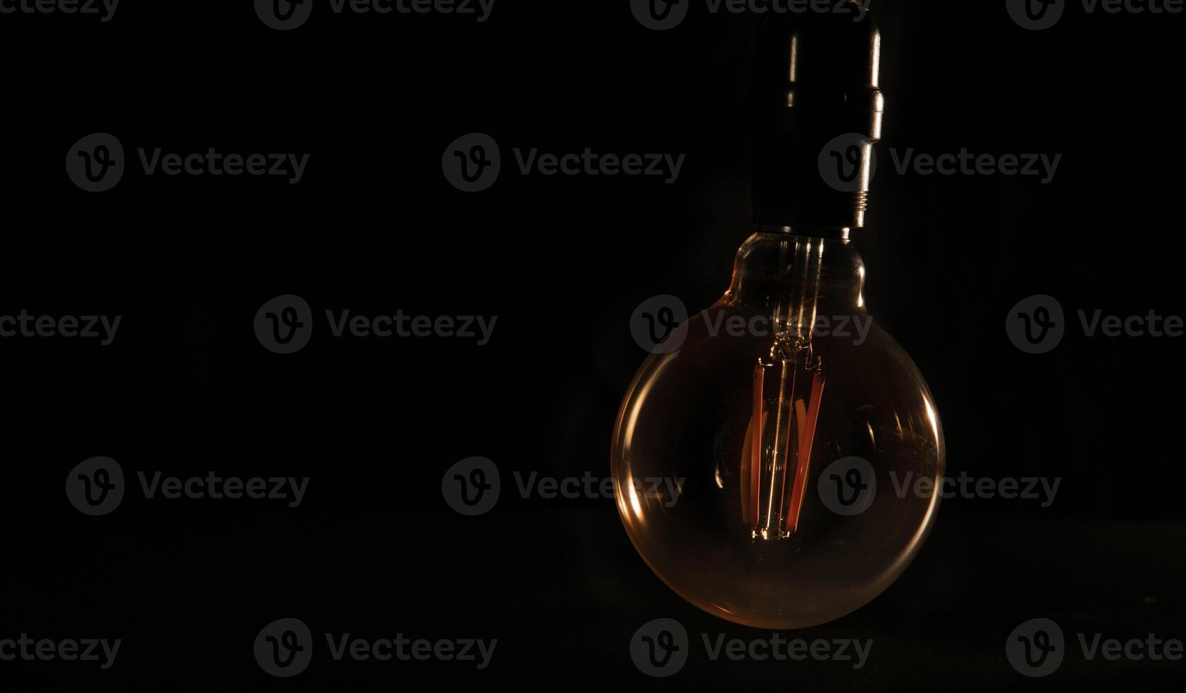 Unlit glass bulb without electricity hanging with warm reflections photo