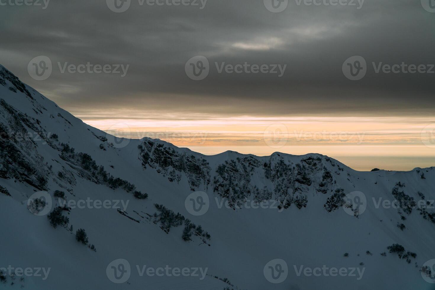 View of the winter sunset and snow-covered mountains photo