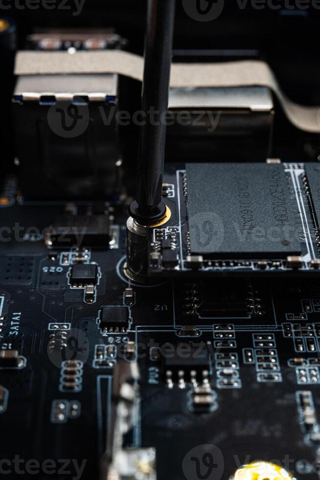 Screwing MSATA nvme M2 with a screwdriver for connecting fast modern SSD photo