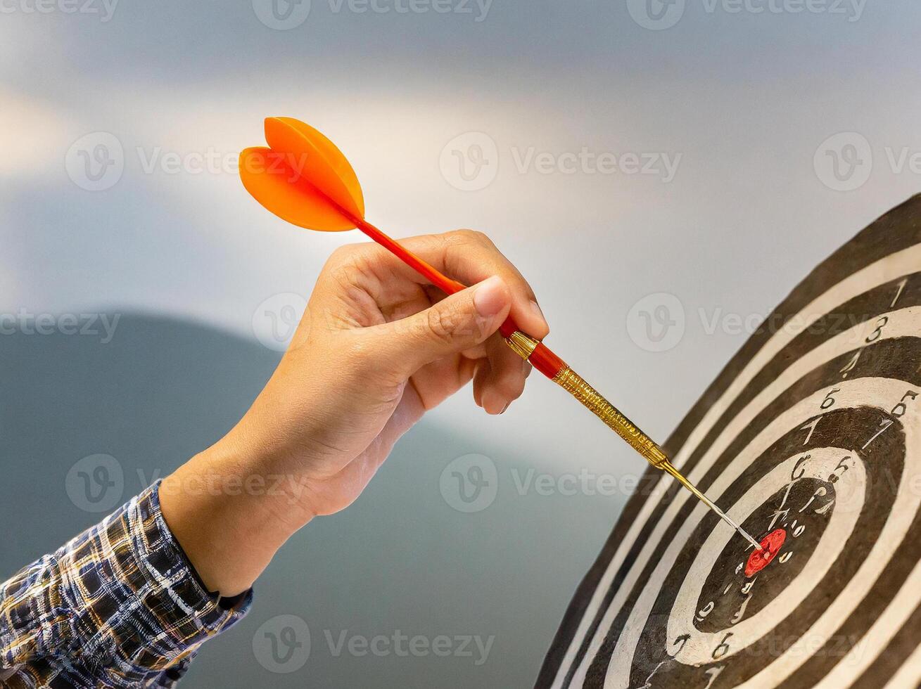 A dart hitting the bullseye of a dartboard symbolizes achievement and precision in business or sports. Aim the target precisely. photo
