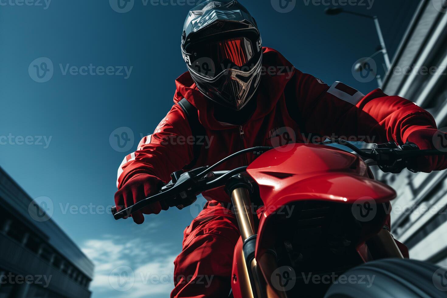 A man in a vibrant red suit riding a matching red motorcycle on the road. photo