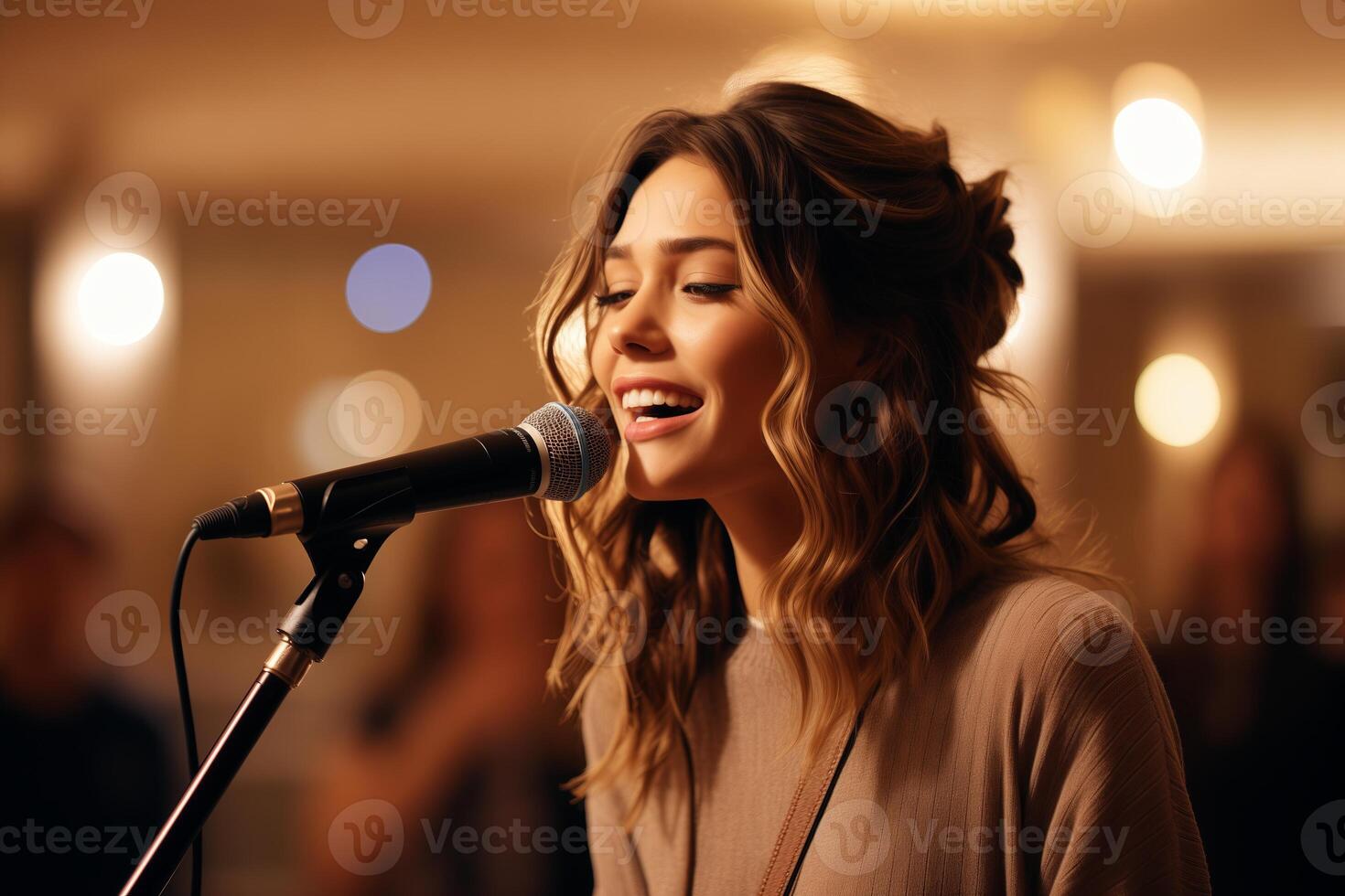 A woman passionately singing into a microphone, expressing herself in a concert hall among many people. photo