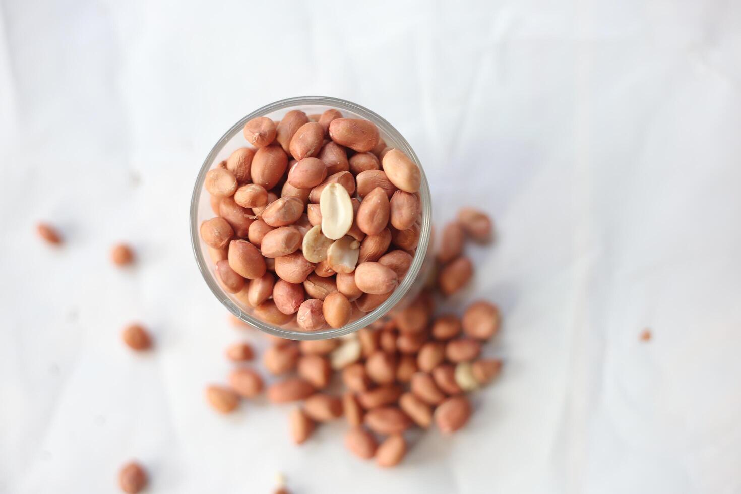 Peanuts are usually made into sauces or peanut butter, close up and selective focus, isolated on white background. photo