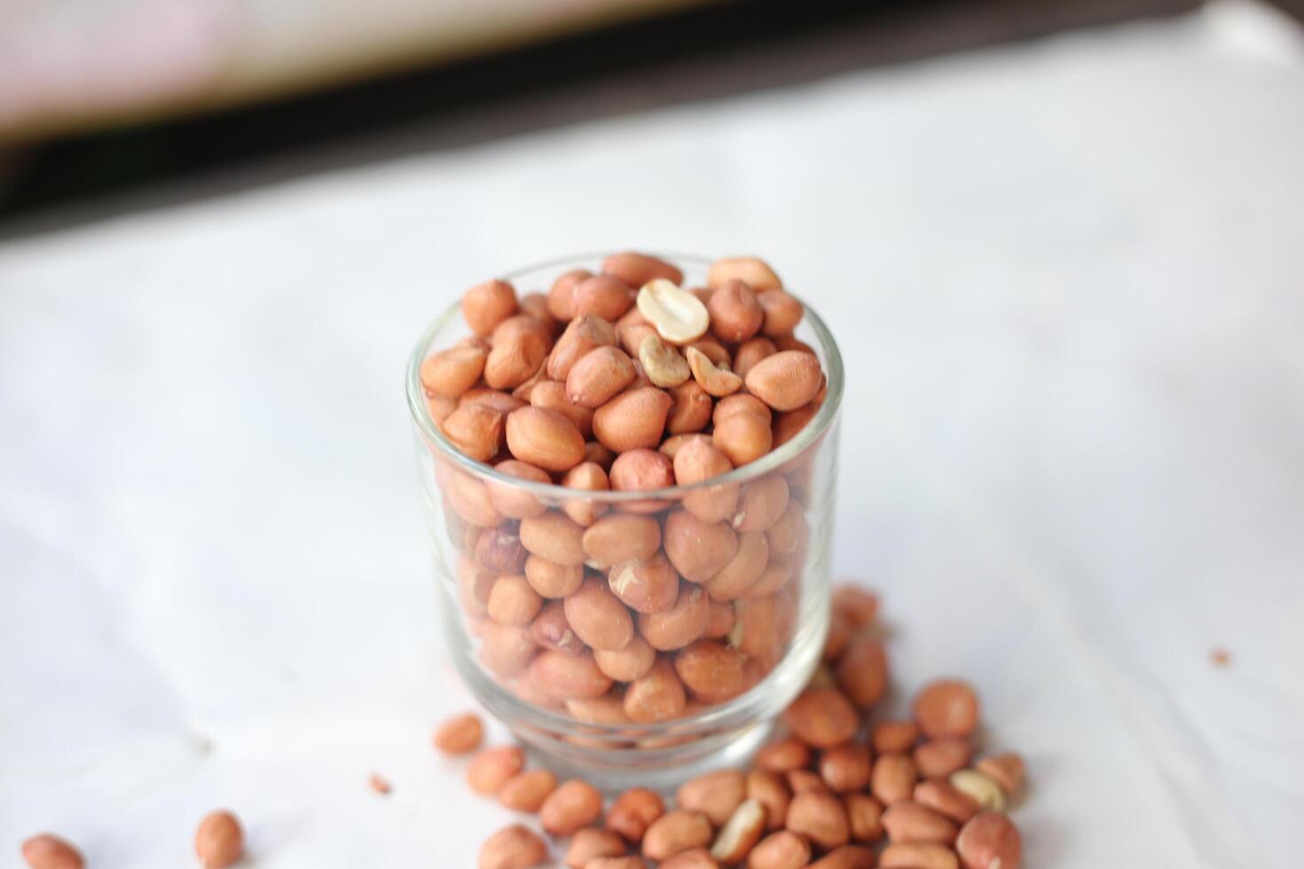 Peanuts are usually made into sauces or peanut butter, close up and selective focus, isolated on white background. photo