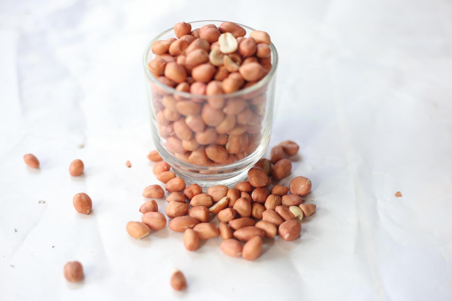 Peanuts are usually made into sauces or peanut butter, close up and selective focus, isolated on white background. photo