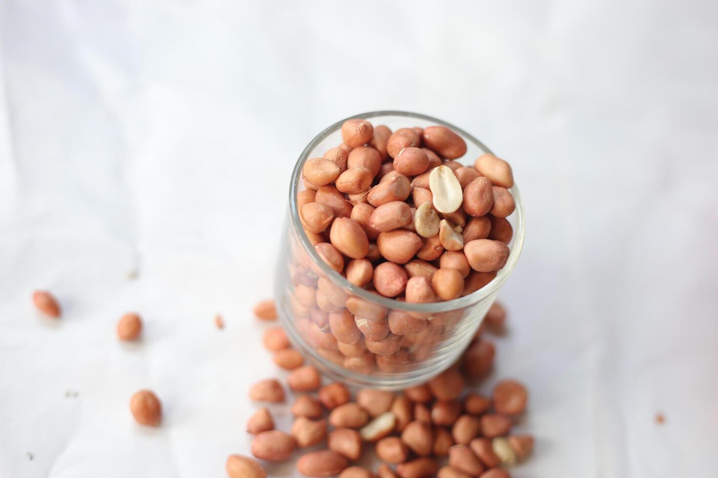 Peanuts are usually made into sauces or peanut butter, close up and selective focus, isolated on white background. photo