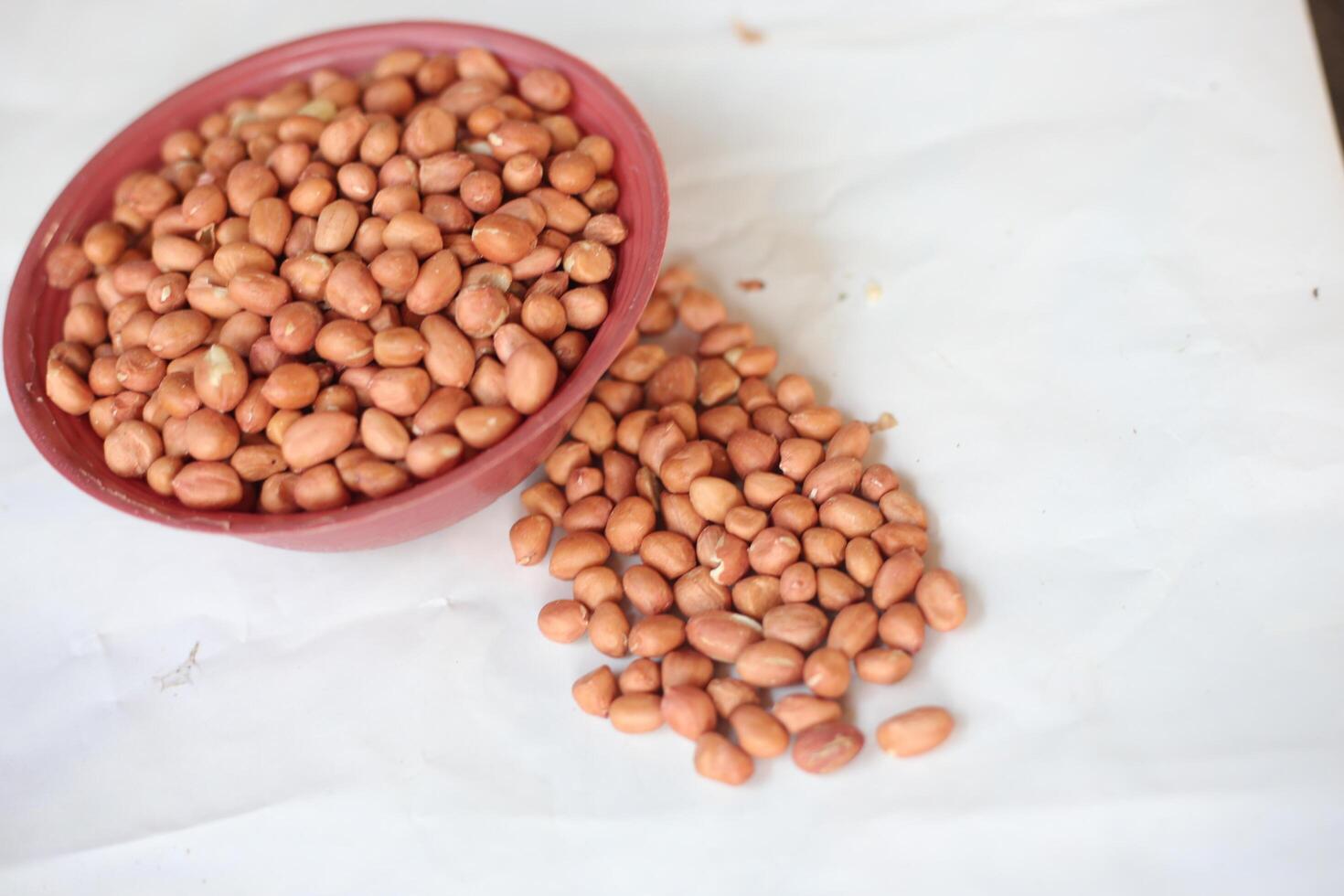 Peanuts are usually made into sauces or peanut butter, close up and selective focus, isolated on white background. photo