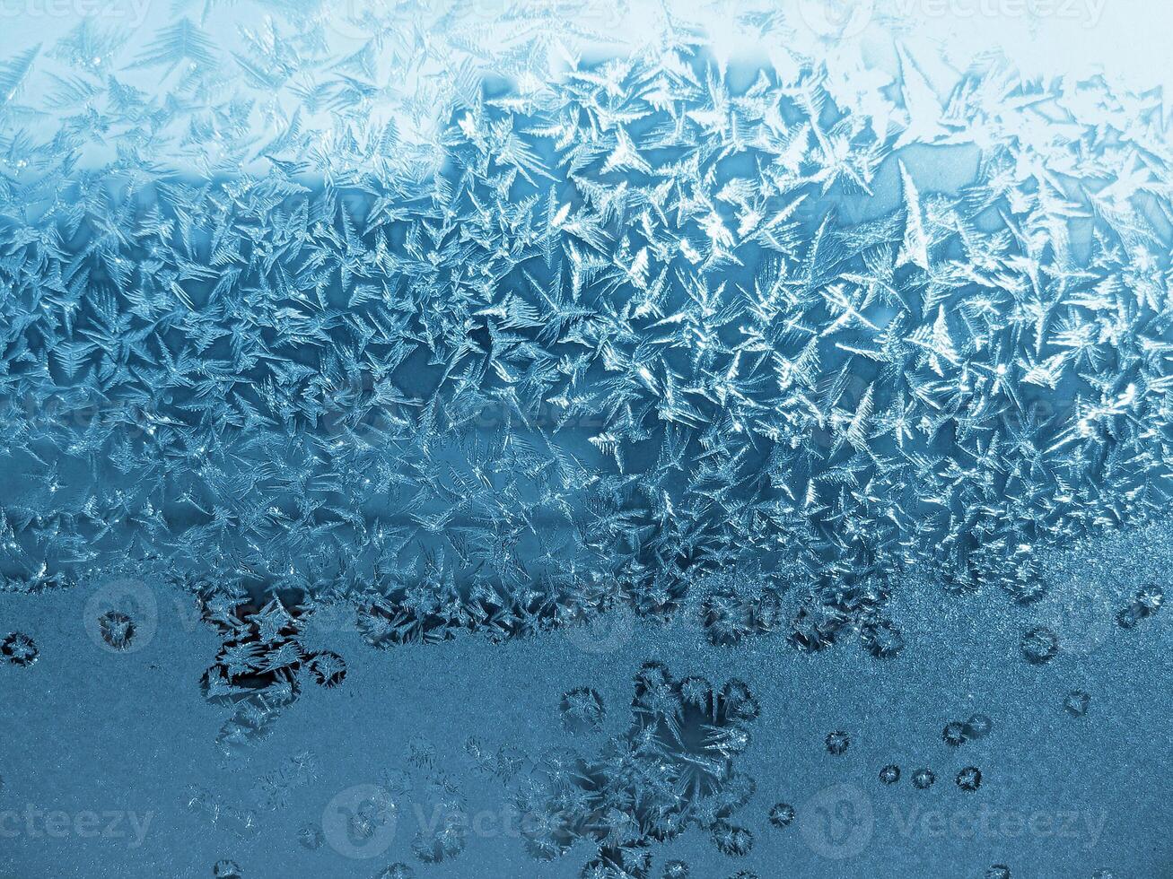 Ice pattern on winter window glass, natural blue background photo