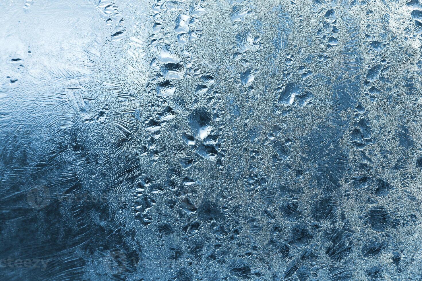 Frozen water drops and ice pattern on glass photo