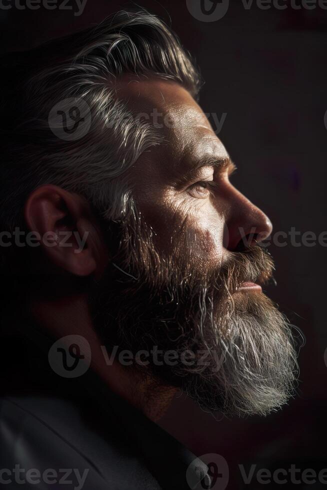 Portrait of serious beard man in low key light side view image photo