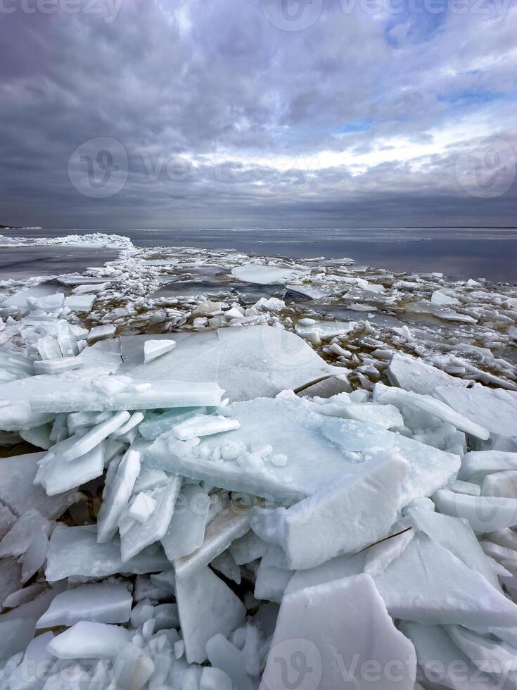 un dramático extensión de roto hielo hojas extensión a el horizonte debajo un temperamental nublado cielo, representando un rígido, frío ártico paisaje foto